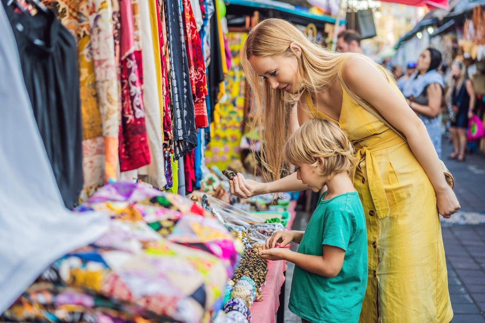 Travellers choosing souvenirs from a stall at Ubud art market